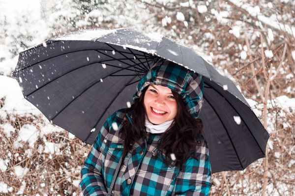 دختر با چتر در نمای نزدیک برف