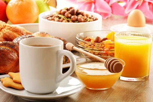 صبحانه شامل قهوه نان عسل آب پرتقال موسلی و میوه ها