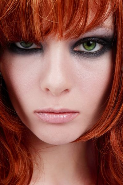 پرتره نزدیک از دختر زیبا با موهای قرمز چشم سبز با آرایش مد روز تیره