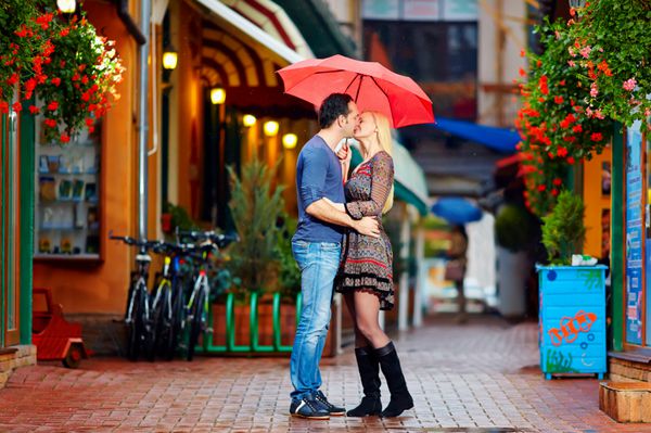زوج عاشق در حال بوسیدن زیر باران