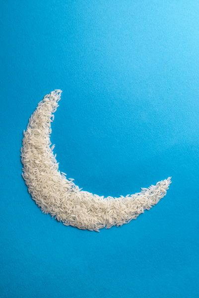 دانه های برنج نپخته که به شکل ماه چیده شده اند