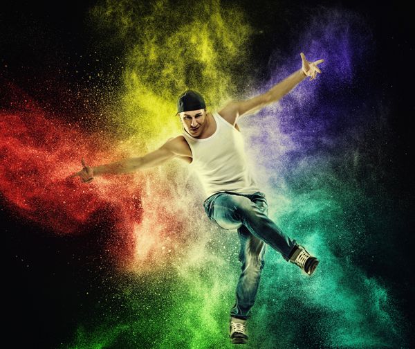 مردی که حرکات بریک رقص را در برابر انفجار پودر رنگارنگ نشان می دهد