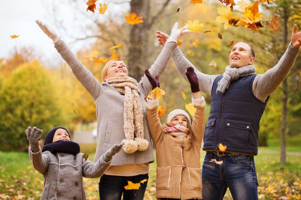 مفهوم خانواده کودکی فصل و مردم - خانواده شاد با برگ های پاییزی در پارک