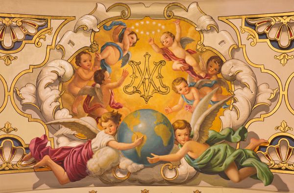 سویل اسپانیا - 29 اکتبر 2014 فرشتگان نقاشی دیواری و مونوگرام مریم باکره روی سقف در کلیسای کلیسا د لا ماکارنا توسط رافائل رودرگز 1949 به سبک نئوک