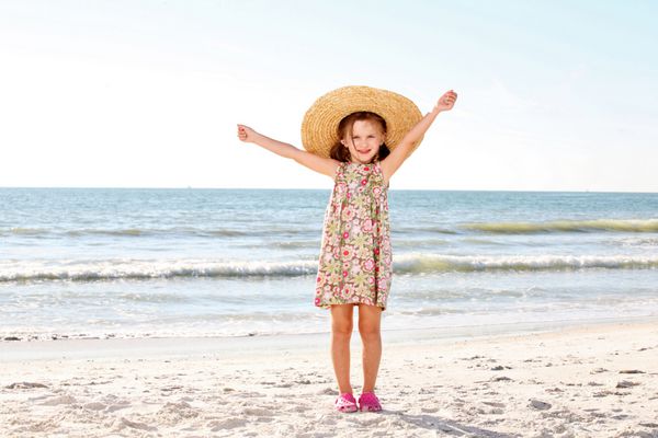 دختر بچه ای در ساحل با کلاه خنده دار
