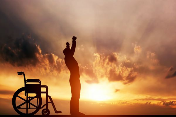 مرد معلولی که هنگام غروب آفتاب از روی صندلی چرخدار ایستاده است مفهوم مثبت درمان بهبودی معجزه پزشکی امید بیمه و غیره