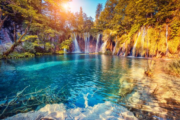 منظره ای باشکوه از آب فیروزه ای و پرتوهای آفتابی در پارک ملی دریاچه های پلیتویس کرواسی اروپا صحنه یکنواخت دراماتیک دنیای زیبایی فیلتر رترو و سبک قدیمی افکت تونینگ اینستاگرام