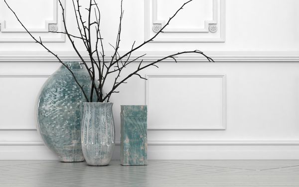 چیدمان مدرن شاخه‌ها در گلدان‌های سرامیکی دست‌ساز با اشکال مختلف که روی زمین در برابر دیواری با پانل‌های سفید با کپی قرار گرفته‌اند رندر سه بعدی