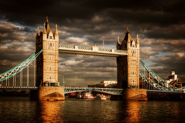 پل برج در لندن انگلستان ابرهای طوفانی و بارانی چشمگیر با درخشش خورشید غروب یکی از نمادهای انگلستان بریتانیای کبیر