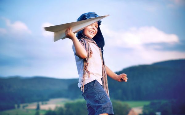 بچه شاد با هواپیمای کاغذی