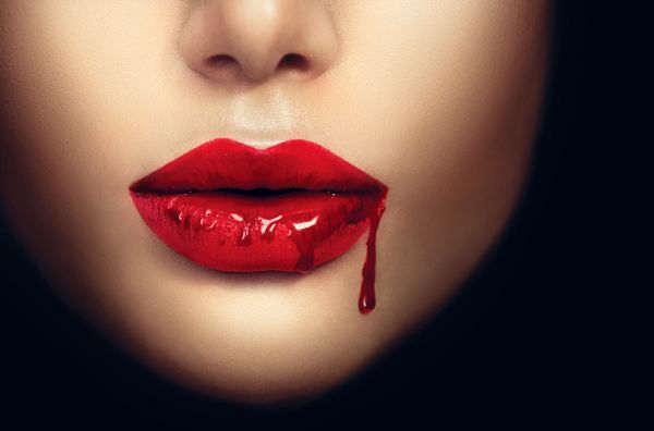لب های زن خون آشام با چکیدن خون طراحی هنری هالووین جذاب مد نمای نزدیک از دهان خون آشام دختر جذاب