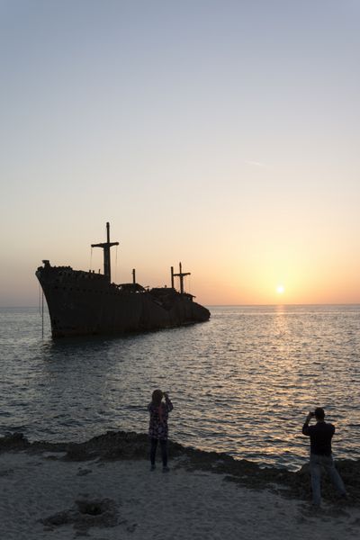 عکس گرفتن با تلفن همراه از لاشه کشتی یونانی در جزیره کیش در غروب آفتاب