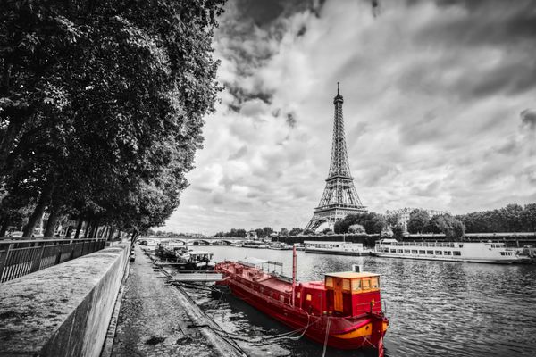 برج ایفل بر فراز رودخانه سن در پاریس فرانسه کشتی توریستی قرمز روی آب قدیمی سیاه و سفید