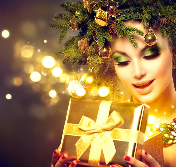 زن زمستانی کریسمس جعبه هدیه جادویی کریسمس را باز می کند پری مدل مو و آرایش زیبای جشن سال نو و درخت کریسمس دختر مدل لباس زیبایی با جعبه حاضر ستاره های جادویی تعطیلات