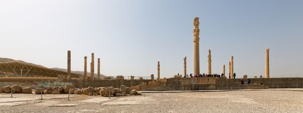 تخت جمشید ایران - 3 مه 2015 بازدیدکنندگانی که در کنار ستون‌های باستانی شهر قدیمی قدم می‌زنند در طول زمان قد علم می‌کنند