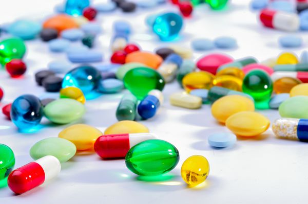انواع کپسول های دارویی و دارو در رنگ های مختلف که نشان دهنده داروها و آنتی بیوتیک های مختلف در یک مفهوم مراقبت های بهداشتی است