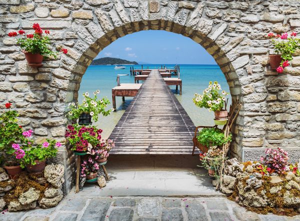 منظره دریا از طریق طاق سنگی با گل در ایتالیا