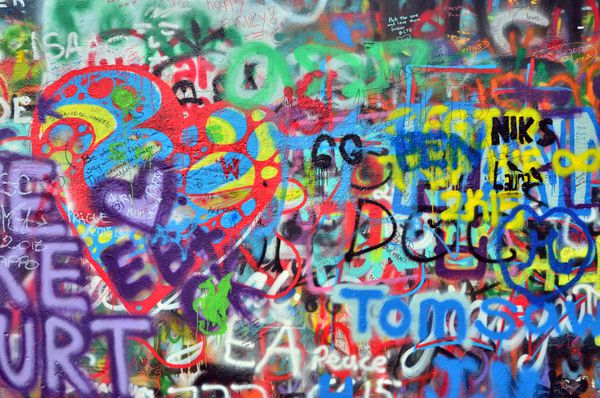 دیواری که با بنرها و گرافیتی های رنگارنگ پاشیده شده است