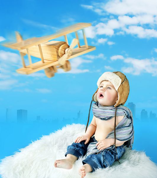 پسر بچه ناز با یک هواپیمای اسباب بازی قدیمی