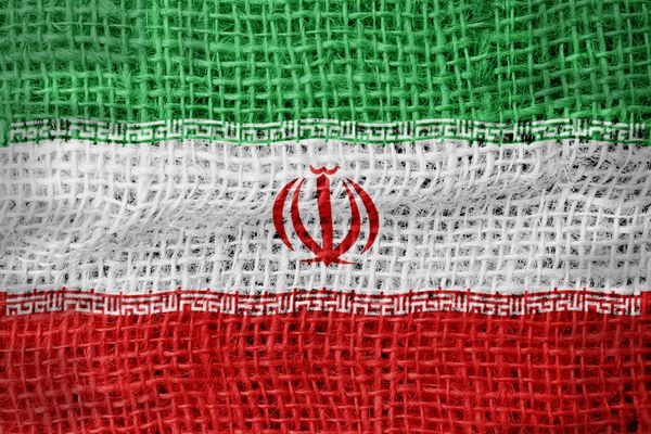پرچم ایران روی پس‌زمینه پارچه‌دار