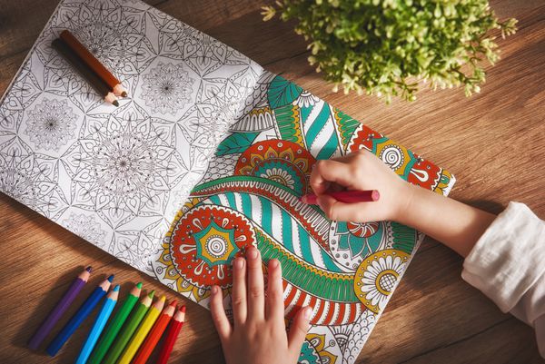 کودک کتاب رنگ آمیزی نقاشی می کند روند جدید کاهش استرس مفهوم ذهن آگاهی آرامش