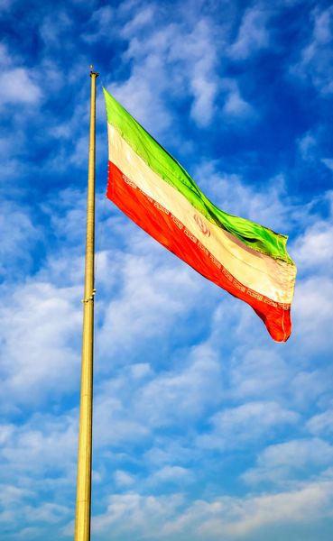پرچم ایران در مقابل آسمان آبی در تهران