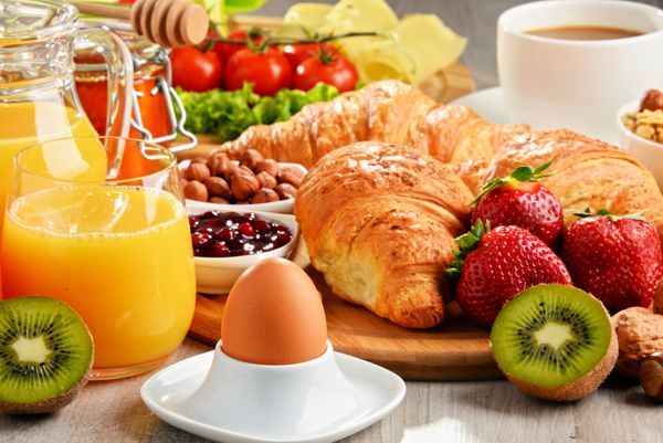 صبحانه شامل کروسانت قهوه میوه آب پرتقال قهوه و مربا است رژیم غذایی متعادل