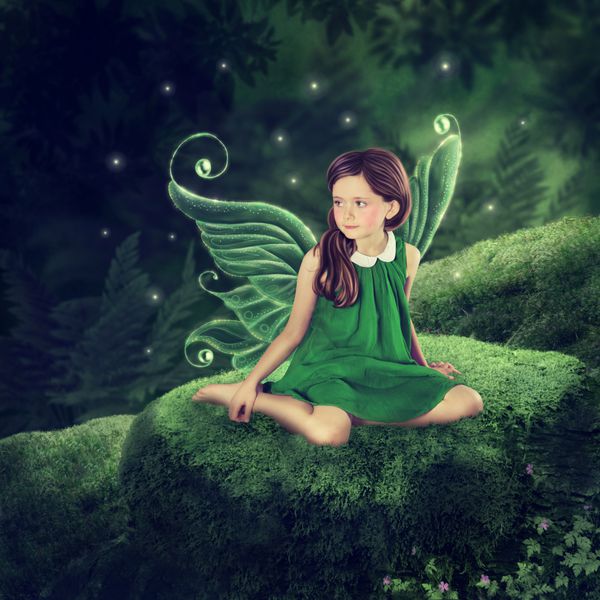 دختر پری کوچکی که در جنگل نشسته است