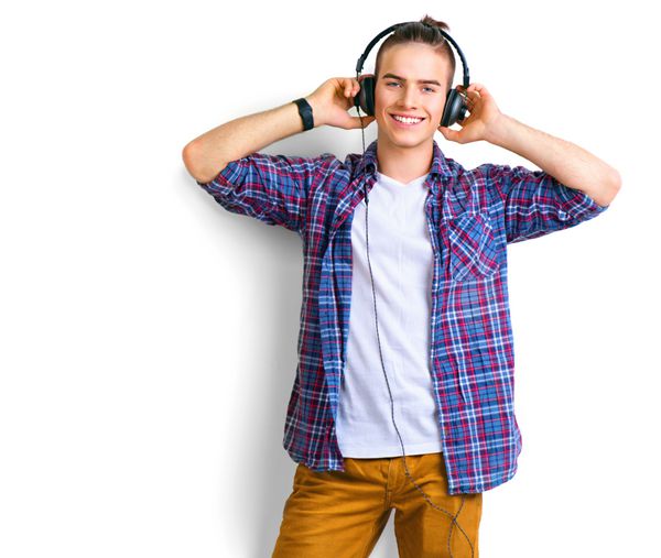 مرد جوان در حال لذت بردن از موسیقی روی هدپ های خود گوش دادن به موسیقی مرد جوان خوش‌تیپ و شیک هدفون در مقابل پس‌زمینه سفید ایستاده و لبخند می‌زند