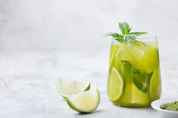 چای سبز سرد ماچا با لیموترش و نعناع تازه روی پس‌زمینه مرمر کپی sp