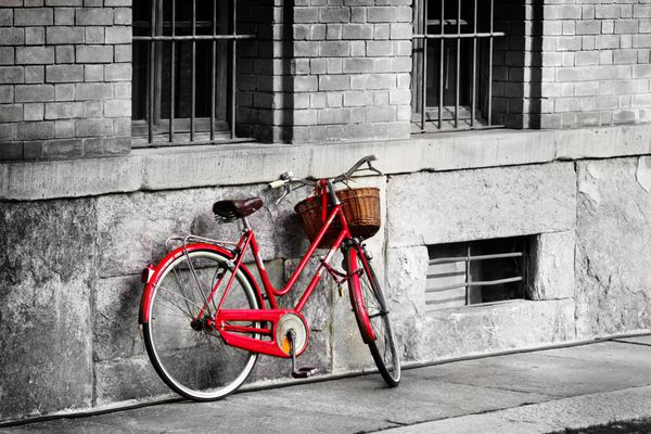 دوچرخه قرمز روشن در خیابان قدیمی فیلتر سیاه و سفید اعمال شد