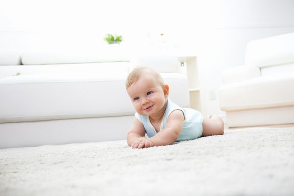 پسر بچه ناز روی فرش دراز کشیده