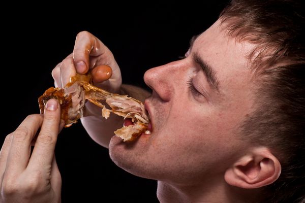 مرد گرسنه در حال خوردن مرغ