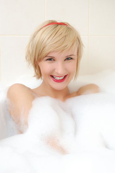زن خندان در حمام حبابی دراز کشیده است