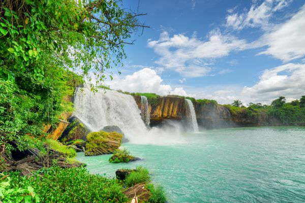 آبشار درای نور بر روی رودخانه سرپوک در میان درختان سبز در تای گوین ارتفاعات مرکزی در استان داک لاک داکلاک ویتنام منظره تابستانی شگفت انگیز با حوض لاجوردی و آسمان آبی