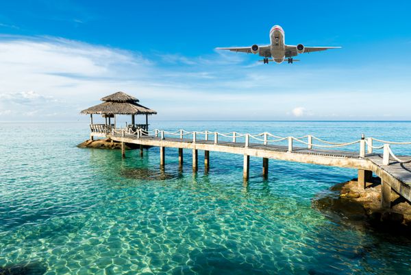 هواپیما صبح در حال ورود به استراحتگاه استوایی است مفهوم سفر تابستان تعطیلات و تعطیلات
