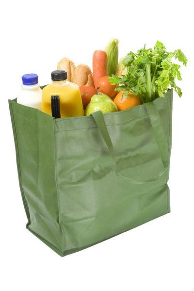 کیسه خرید قابل استفاده مجدد پر از مواد غذایی جدا شده در پس زمینه سفید