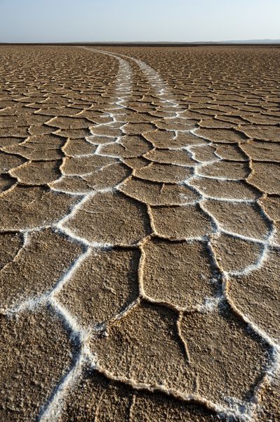 ایران نزدیک خور خور دریاچه نمک مسیرهای تایر سفید در وسط دریاچه نمک با نقوش و افقی منحصر به فرد در پس زمینه