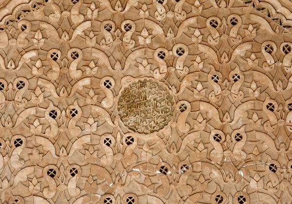 نقش‌های زیبا غنچه‌های گل و خط‌های اسلامی حک شده در دیوارها و سقف‌های مسجد بن یوسف در منطقه مدینه مرکزی مراکش مراکش