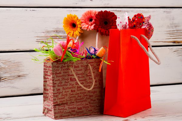 کیسه هایی با گل و آب نبات کیسه های کاغذی ژربرا کمان های پارچه ای هدایایی برای تمام خانواده آماده کنید روز خرید