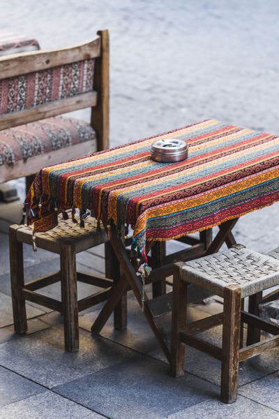 کافه دکوراسیون سنتی شرقی پتوی رنگارنگ با حاشیه و تزئینات صندلی های کوچک دنج