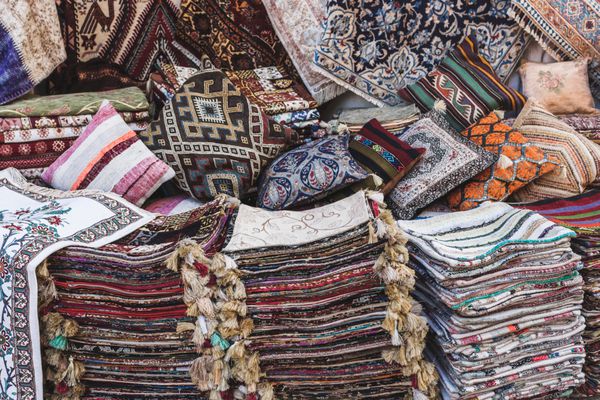 توده ای از فرش های دستباف زیبا در بازار در بازار بزرگ استانبول پس زمینه چند رنگ