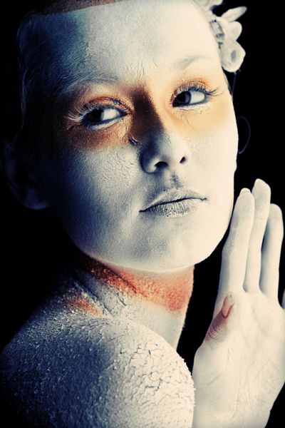پرتره یک زن هنرمند با رنگ‌های سفید و برنز روی پس‌زمینه سیاه نقاشی شده است پروژه نقاشی بدن