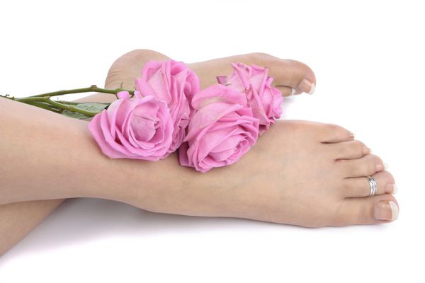 پاهای زن و گل روی پس زمینه سفید