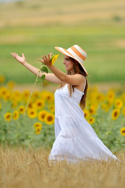 زن جوان در مزرعه گل آفتابگردان در تابستان