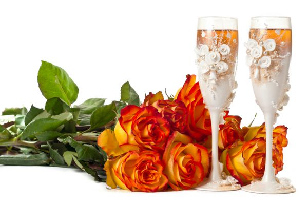 یک لیوان شامپاین و یک گل رز در پس زمینه سفید