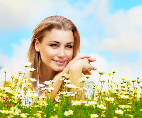 دختر زیبای جوانی که در مزرعه گل های دیزی دراز کشیده است پرتره در فضای باز مفهوم سرگرم کننده تابستانی