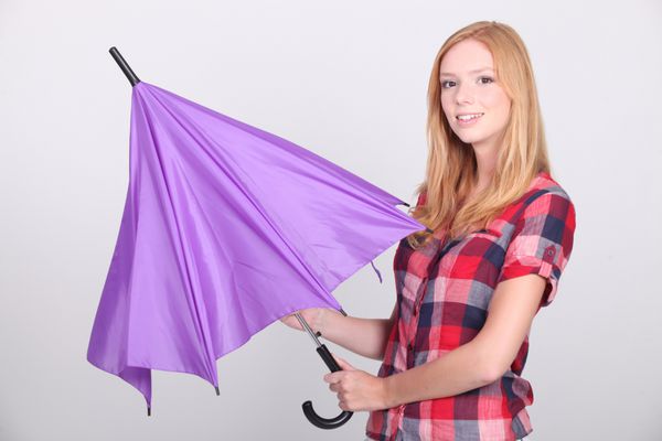 زن جوانی که چتر بنفش را باز می کند