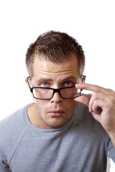 مردی که عینک خود را تنظیم می کند تا دید بهتری داشته باشد