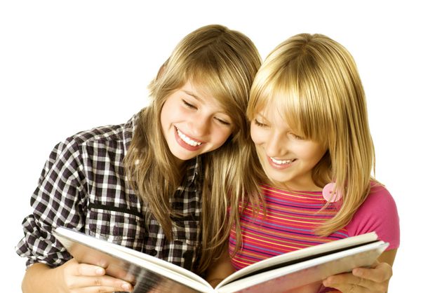 دو دختر نوجوان در حال خواندن کتاب آموزش